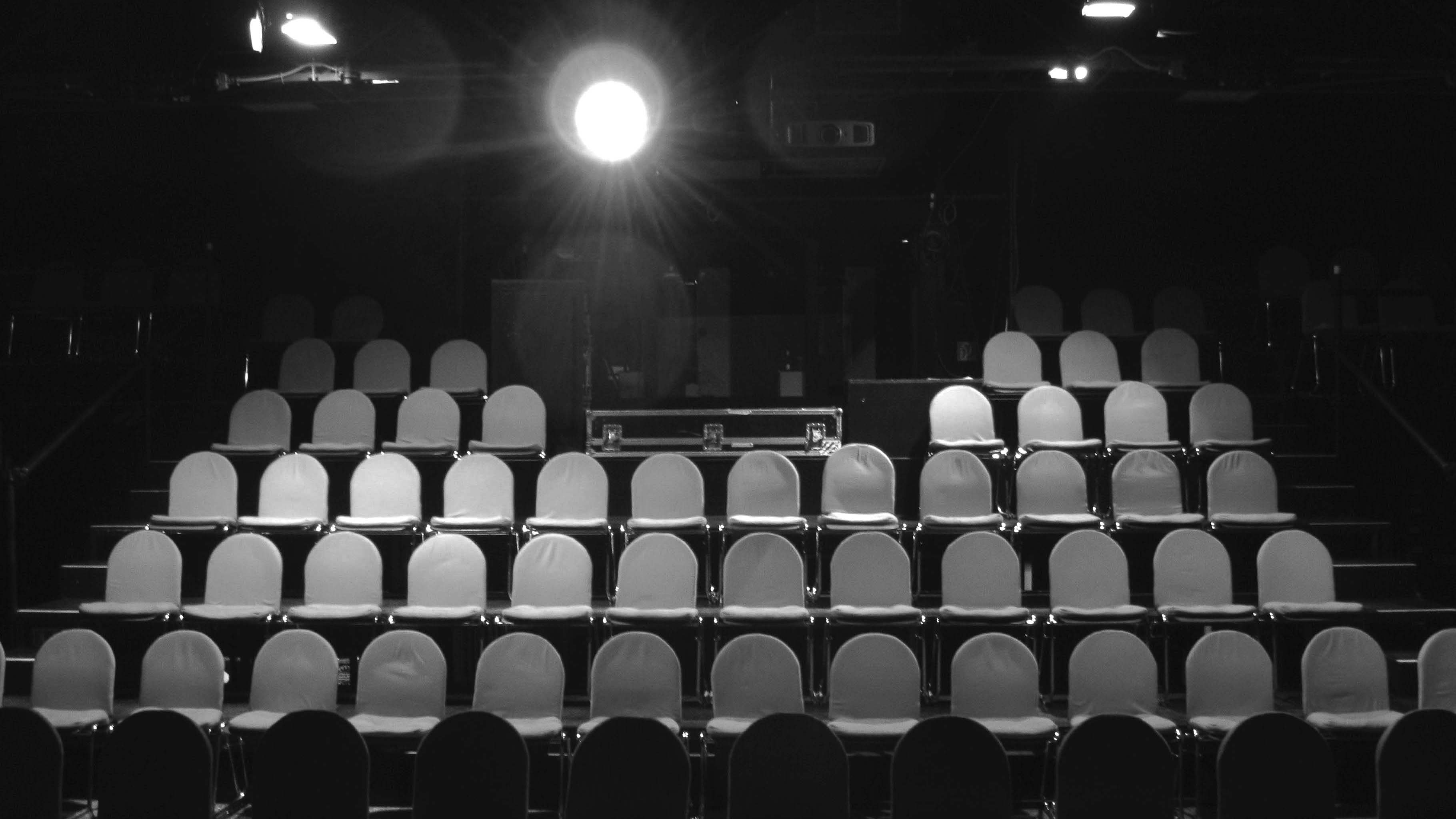 Schwarz-weiße Frontalaufnahme des Kinosaals der Cinémathèque in der naTo